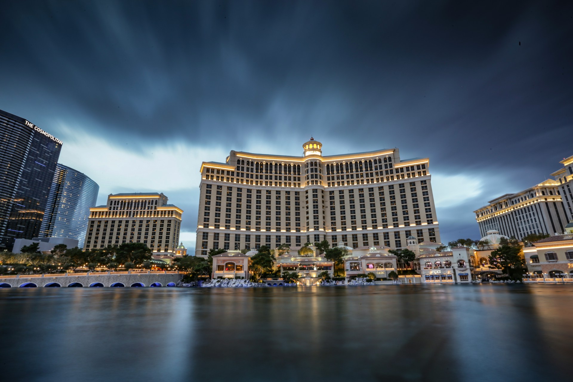 A grand hotel standing behind a waterfront