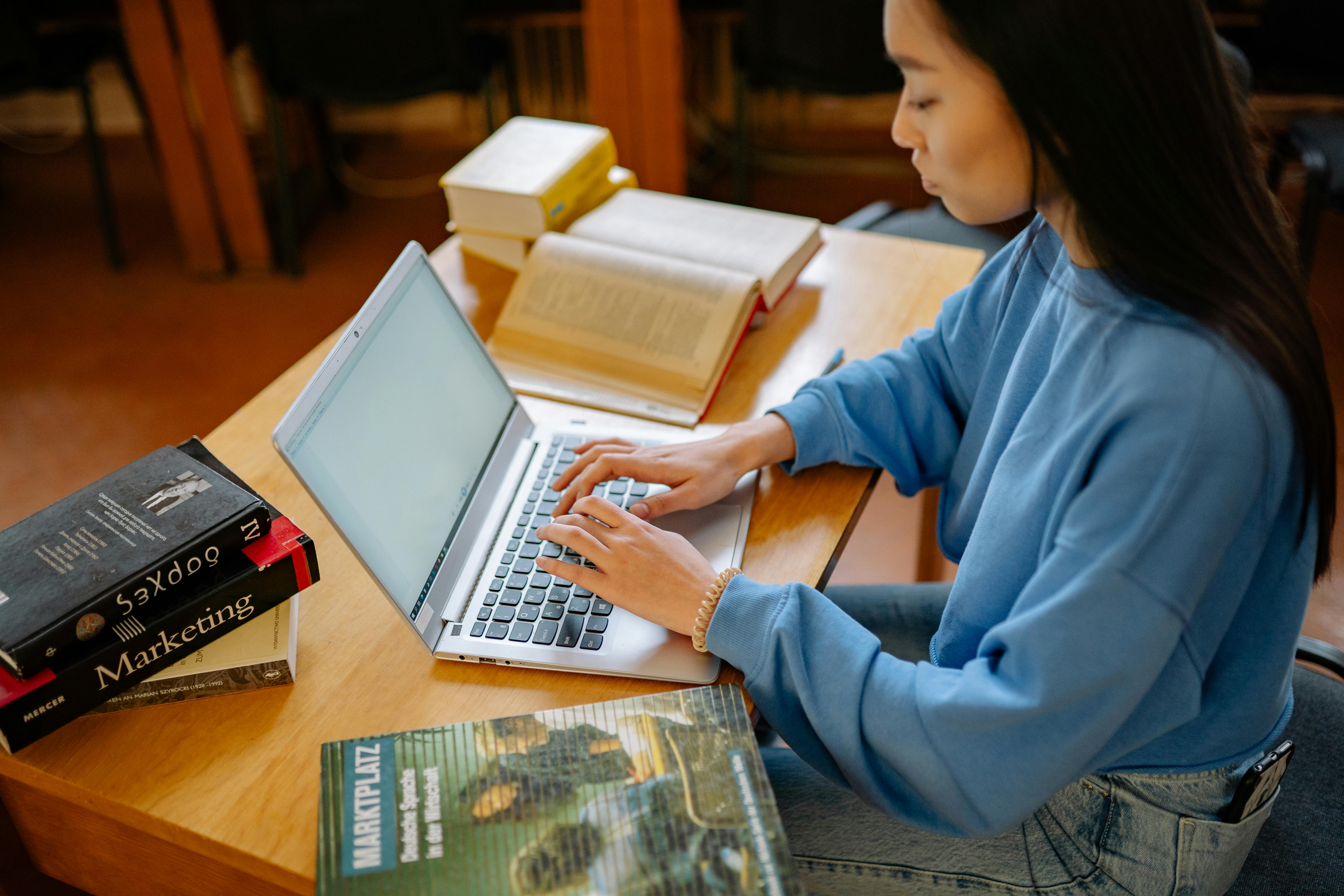 student types on laptop in library