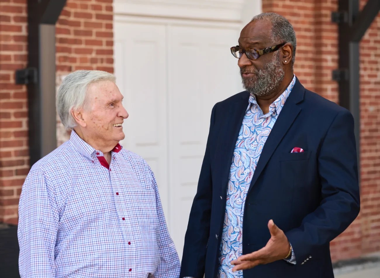 A photo of Alton and Wane engaging in friendly conversation.